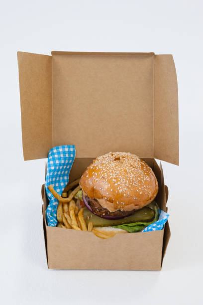 istock Hamburger and french fries in a take away container on table 825736922