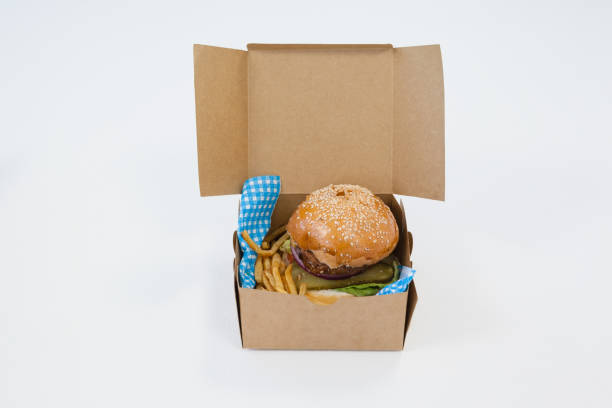 istock Hamburger and french fries in a take away container on table 825736936