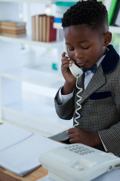istock Businessman talking on landline phone while looking at book 825737114