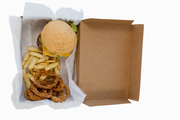 istock Hamburger, onion ring and french fries in a take away container on table 825737220