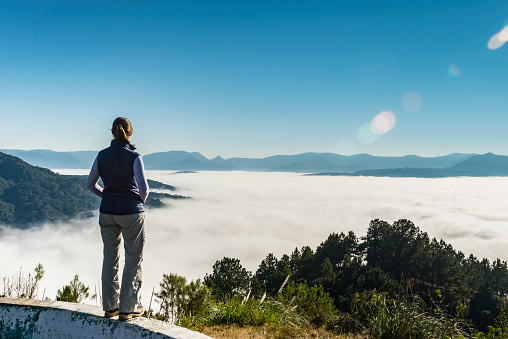 View of a woman at a viewpoint and the mist over Urubici city at the 'Serra Catarinense' in Santa Catarina state - Brazil