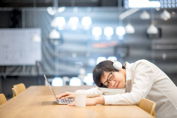 estudiante de la universidad asiática joven tomar una siesta sobre pila de libro en hacer la tarea en la biblioteca - sleeping high school desk education fotografías e imágenes de stock