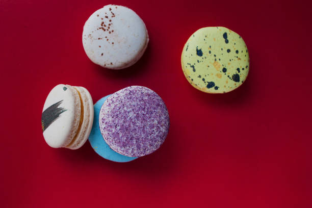 istock Lot of beautiful macarons. Red background, top view. Different tastes 825742626