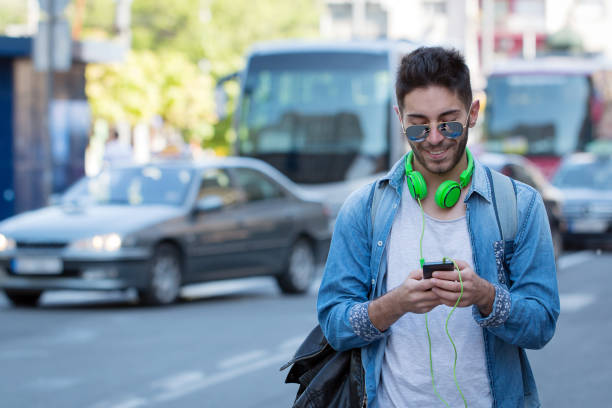 istock Smiling man texting and listening music 825743018