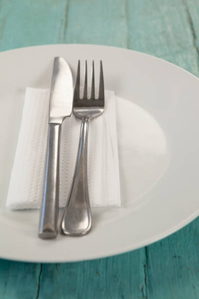 istock White plate with cutlery and napkin on table 825751014