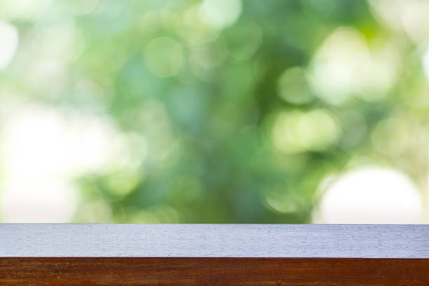 istock Wood table on the background blurred green nature. 825758418