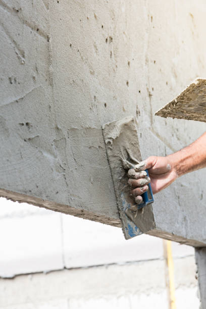 istock Mason plastering the concrete to build wall, Construction under  building with mason plastering concrete to brick wall 825759114