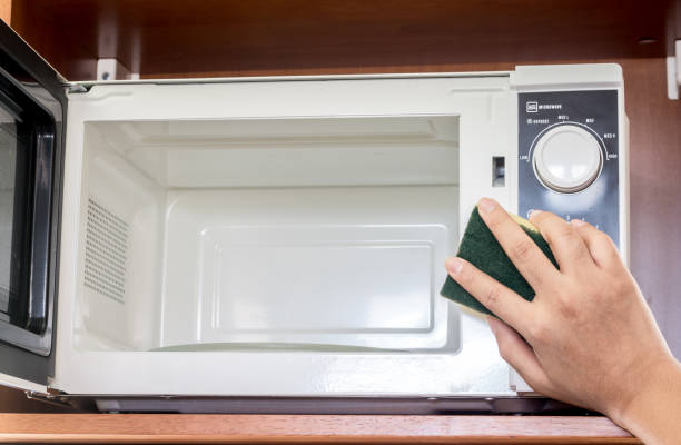 istock Hand cleaning outside of microwave oven 825761532
