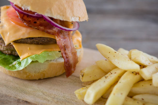 istock Burger with French fries served on cutting board 825762696