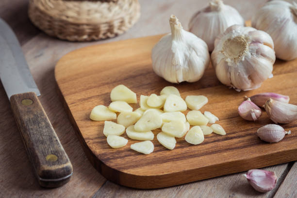 Garlic on wooden cutting board Garlic on wooden cutting board garlic bulb photos stock pictures, royalty-free photos & images