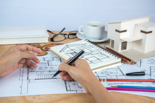 istock designer's hand working with home model & illustration 825770514