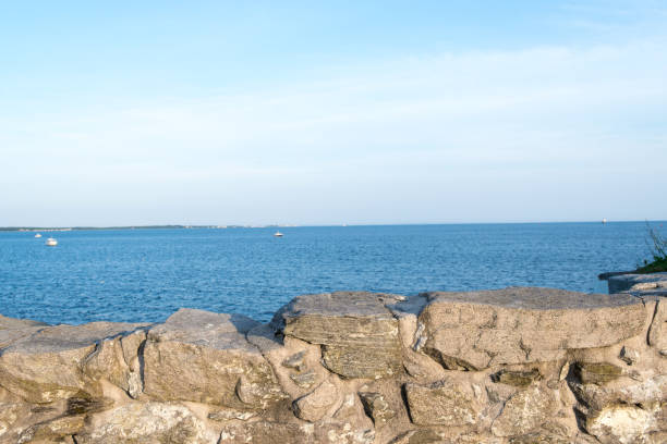 Stone wall and sea during sunset stock photo