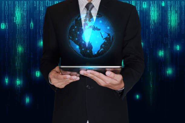 istock Businessman hold tablet and glowing blue world on matrix background 825785596