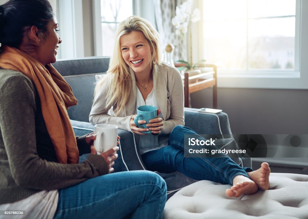 The best coffee is the one we drink with friends Shot of two young women having coffee together on a relaxing day at home Friendship Stock Photo