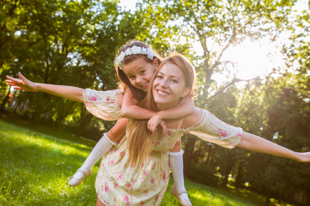 istock Smiling mother giving her daughter piggyback ride 825789412