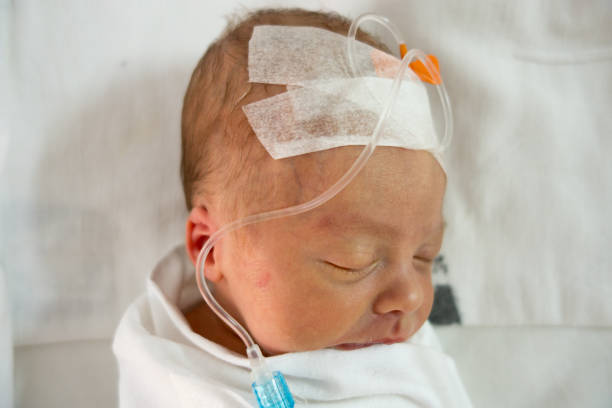 istock Newborn baby sleeping on a drip in a hospital 825789566