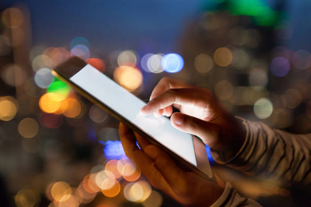 istock hand using digital tablet on night beauty light bokeh in city 825796608