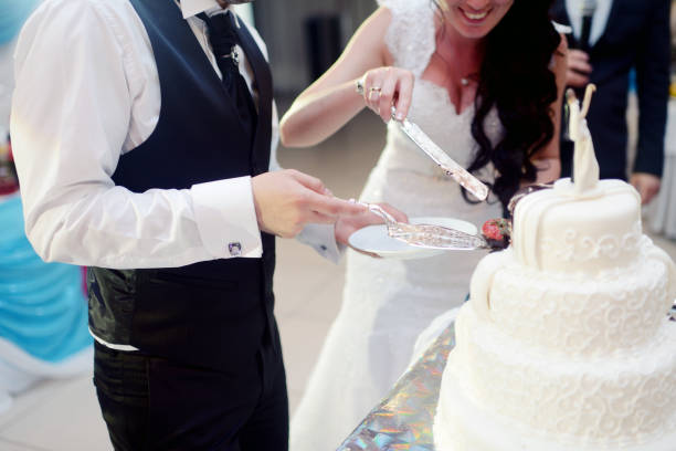 istock Beauty bride and handsome groom are cutting a wedding cake 825804126