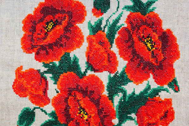 istock Red poppies embroidered on gray fabric. 825810938
