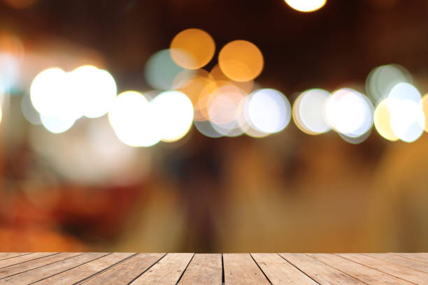 istock Wooden table on font and blurred warm orange colorful background 825818236