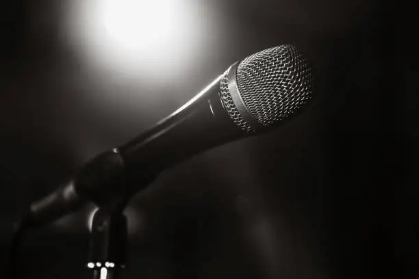 Photo of Black and white image of the microphone. The microphone on the stage is close-up. A pub. Bar. A restaurant. Classical music. Music