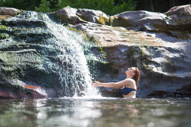 frau genießen sie im wasserfall baden - waterfall water nature zen like stock-fotos und bilder