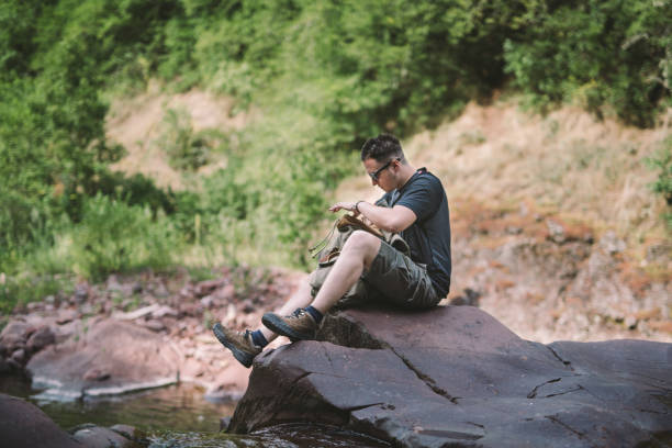 istock Hiker sitting next to the waterfall 825821688