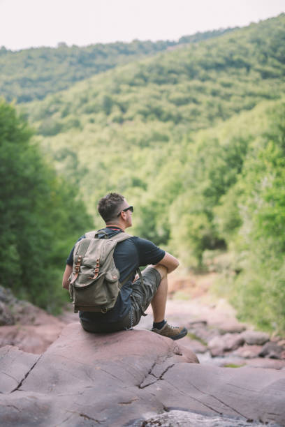 istock Hiker sitting next to the waterfall 825821758