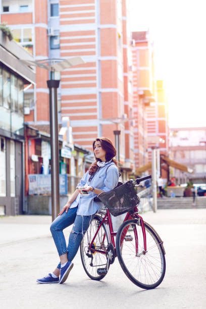 istock Beautiful young woman with bicycle in urban environment. 825826656