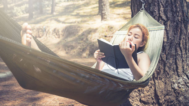 istock Sleeping women write notes. In the hammock. In the natural atmosphere in the park 825828434
