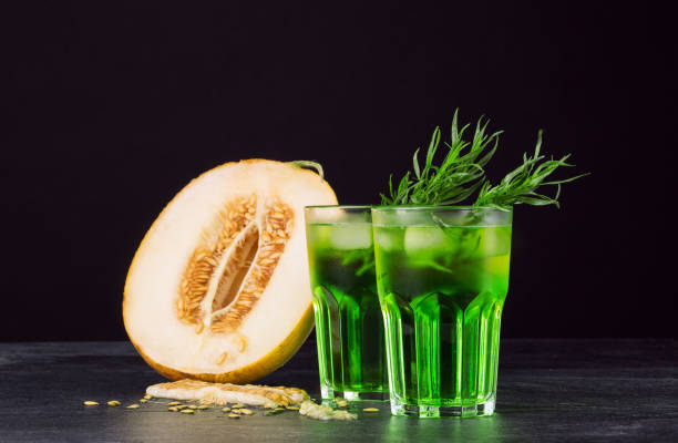 istock Green alcohol cocktails. Cold drinks and a melon on a black background. Drinks with tarragon, ice and sweet melon. Copy space. 825831042