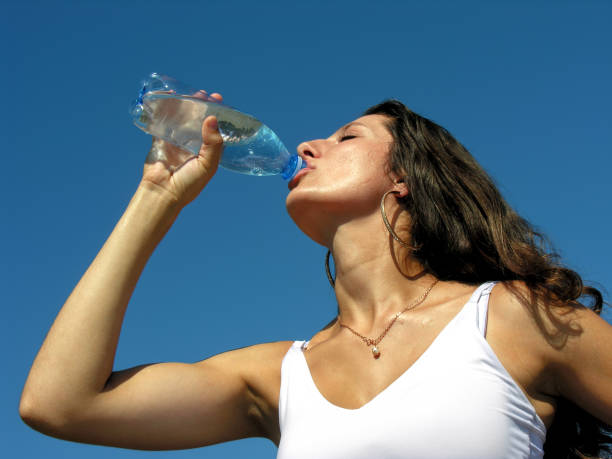 jovem mulher bebe água fria em dia quente - hot water bottle - fotografias e filmes do acervo