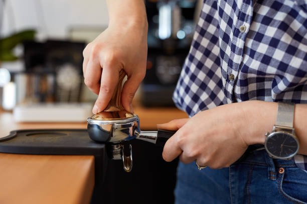 istock Barista tamping freshly ground coffee 825834508