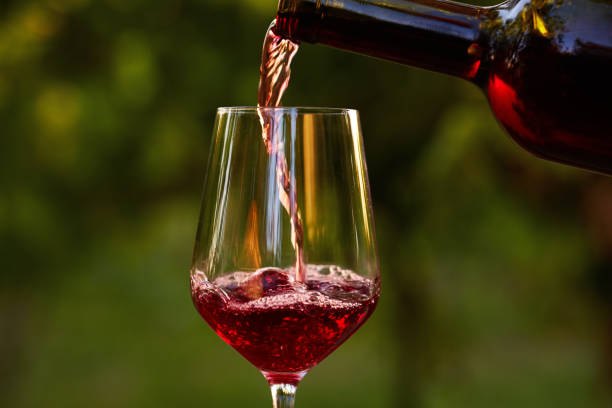 istock Pouring red wine into glass 825834604