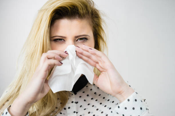 istock Woman being sick having flu sneeze into tissue 825835084