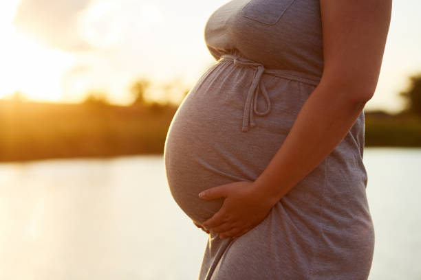 istock Pregnant woman touching her belly 825835476