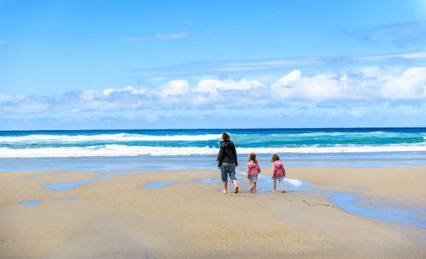 istock Mother and children are walking on sandy Atlantic beach. 825837812