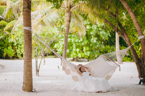 istock Beautiful bride lies on a hammock on the beach 825845648