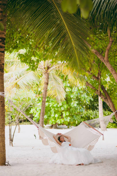 istock Beautiful bride lies on a hammock on the beach 825845656