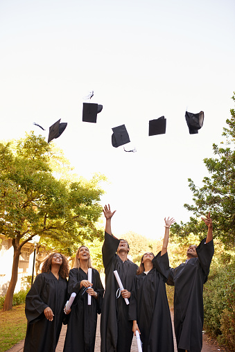 Cropped shot of a group of university students throwing their hats into the air on graduation day