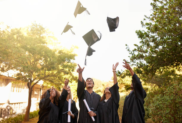 Graduation is a time for celebrating an achievement Cropped shot of a group of university students throwing their hats into the air on graduation day graduation throwing cap stock pictures, royalty-free photos & images
