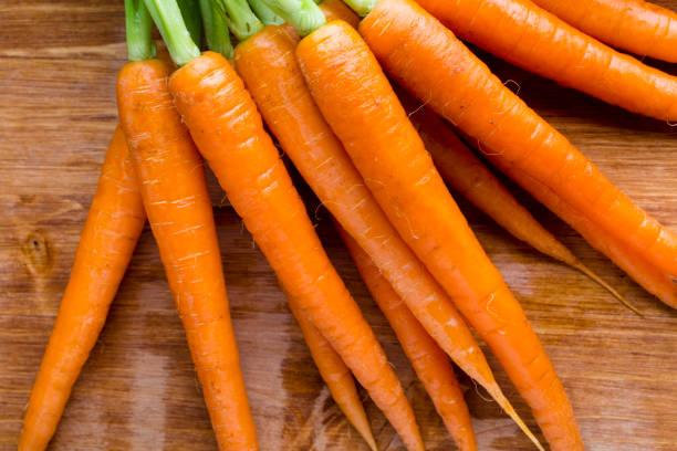istock Fresh carrots on the wooden background. 825850644