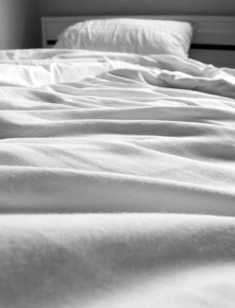 istock White blanket crumpled on the bed 825854274