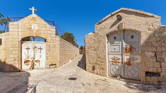 Entrance to Christian cemetery and narrow walkway near Abbey of Dormition in Jerusalem, Israel (panorama).