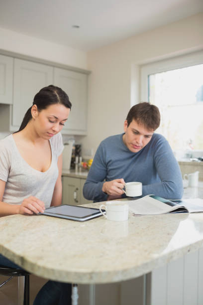 istock Two people reading from tablet pc and magazine 825861892