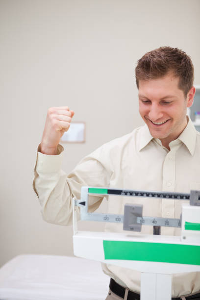 istock Man celebrating his victory over the scale 825866176