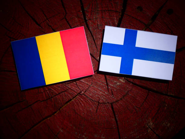 istock Romanian flag with Finnish flag on a tree stump isolated 825869264