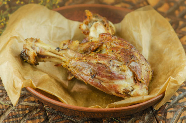 istock Roasted lamb meat with vegetables on wooden background 825869270