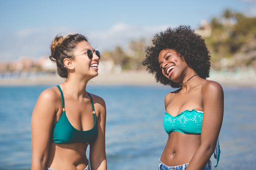Portrait of two young female friends at seaside laughing