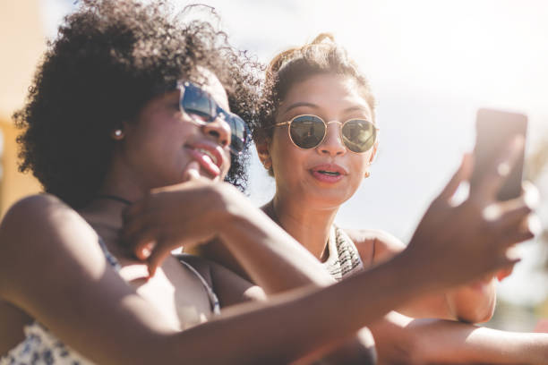 istock Two young women looking at smartphone 825873628
